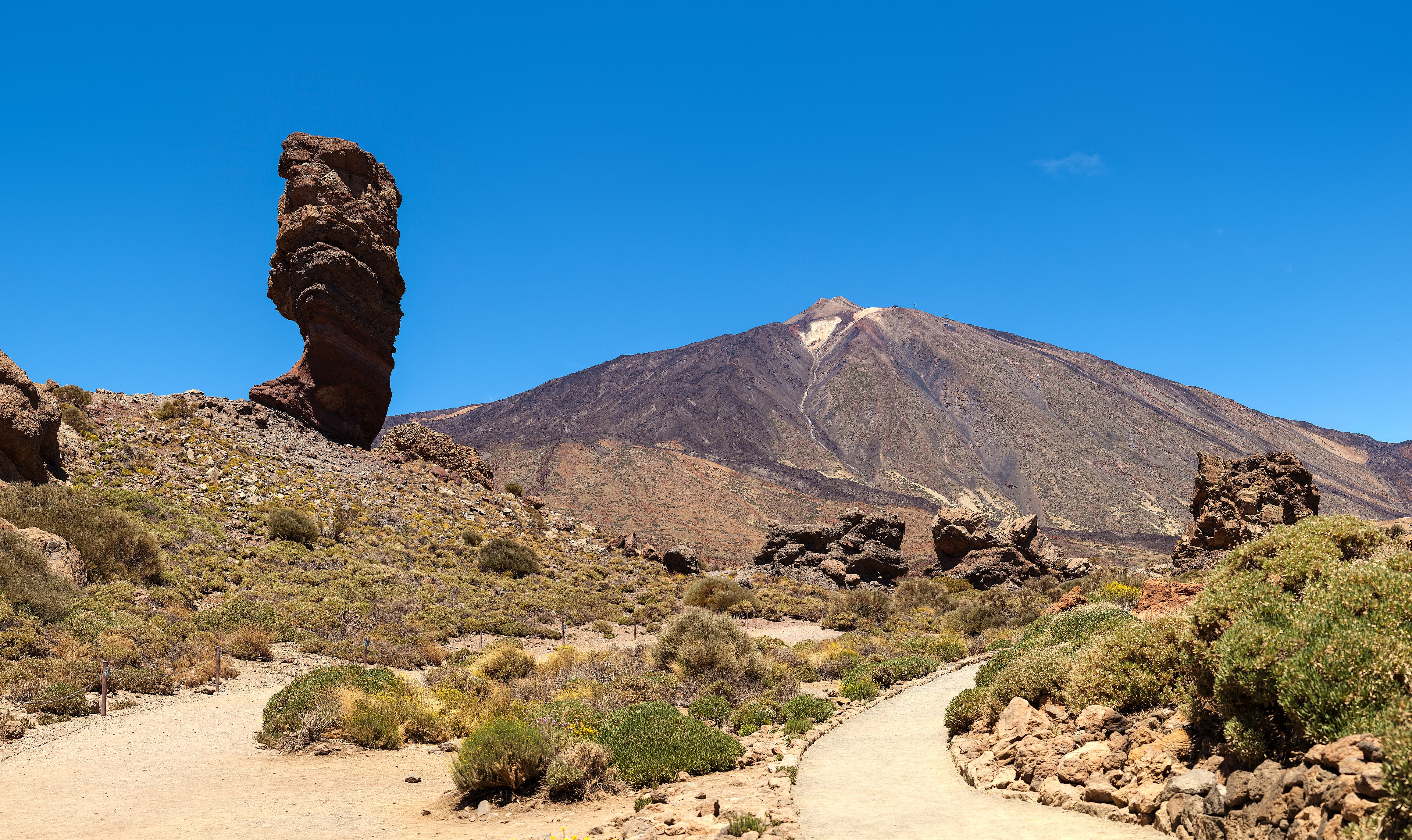 El Roque Cinchado en primer plano y el volcán Teide al fondo bajo un cielo azul, Tenerife, Islas Canarias